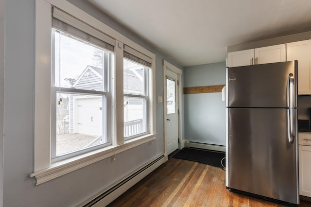 kitchen with baseboard heating, white cabinetry, freestanding refrigerator, and dark wood-style flooring