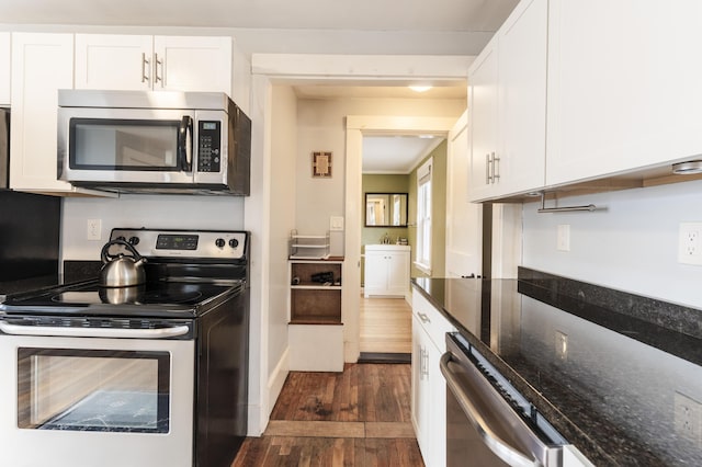 kitchen with dark stone counters, white cabinets, dark wood-style floors, and stainless steel appliances