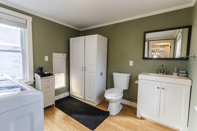 bathroom with toilet, vanity, washer / clothes dryer, and wood finished floors