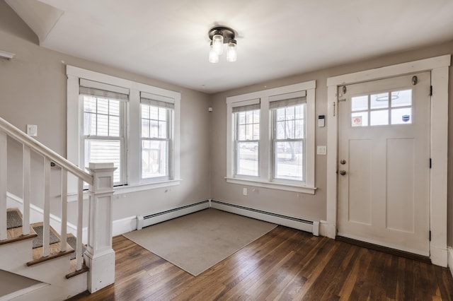 entryway with dark wood finished floors, stairway, a baseboard heating unit, and a wealth of natural light