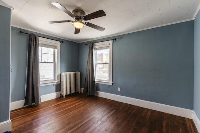 unfurnished room featuring radiator heating unit, wood finished floors, and a healthy amount of sunlight