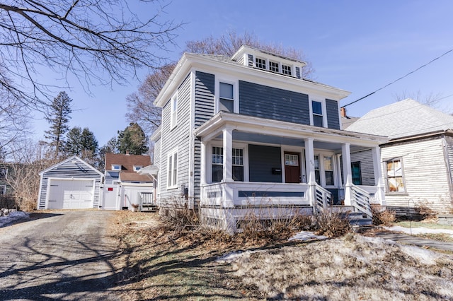 traditional style home with an outdoor structure, a garage, covered porch, and driveway