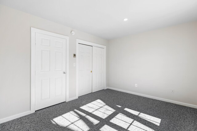 unfurnished bedroom with recessed lighting, carpet, baseboards, and a closet