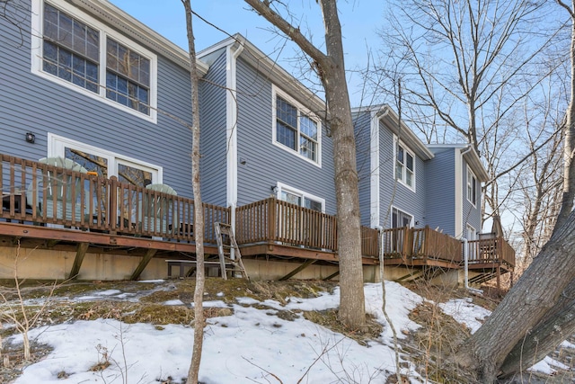 snow covered house with a wooden deck