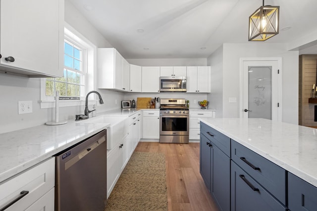 63 Grandview Dr, Newport, ME 04953 - kitchen with light wood finished floors, stainless steel appliances, light stone countertops, and white cabinetry