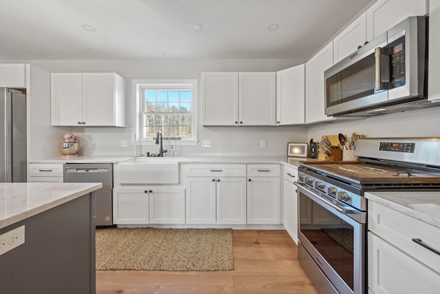 63 Grandview Dr, Newport, ME 04953 - kitchen featuring white cabinets, stainless steel appliances, light wood finished floors, and a sink
