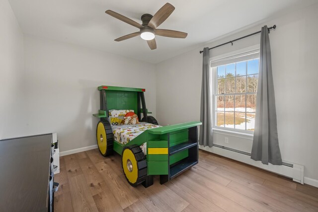 63 Grandview Dr, Newport, ME 04953 - bedroom featuring a baseboard heating unit, baseboards, light wood-style floors, and ceiling fan