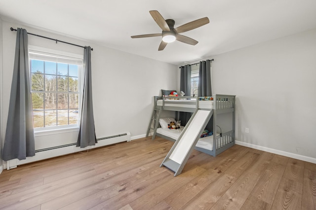 63 Grandview Dr, Newport, ME 04953 - unfurnished bedroom with a baseboard radiator, light wood-style floors, baseboards, and ceiling fan