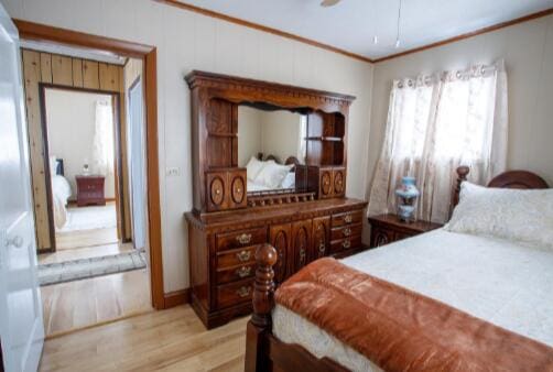 bedroom with light wood-style flooring and ornamental molding