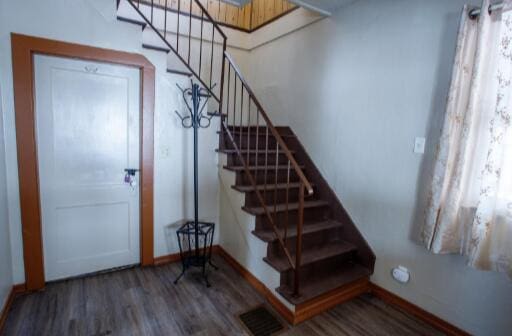 interior space featuring stairway, baseboards, visible vents, and wood finished floors