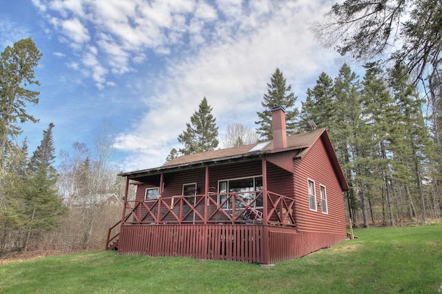 62 Hernborg Rd, Rangeley, ME 04970 - rear view of property featuring a yard, a chimney, and roof with shingles
