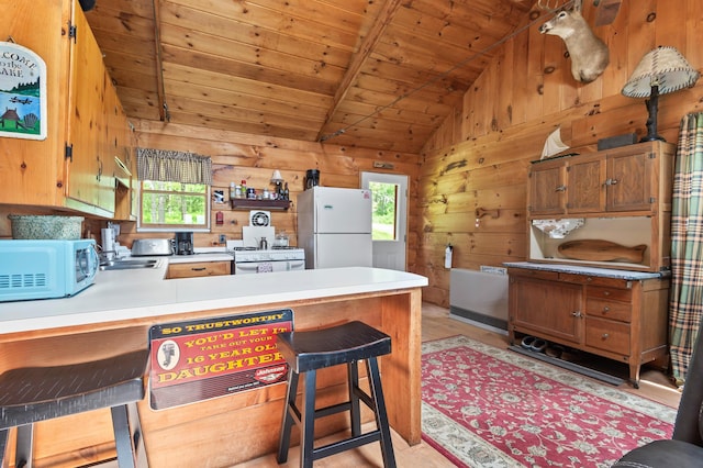 62 Hernborg Rd, Rangeley, ME 04970 - kitchen with white appliances, a peninsula, wooden ceiling, wooden walls, and light countertops