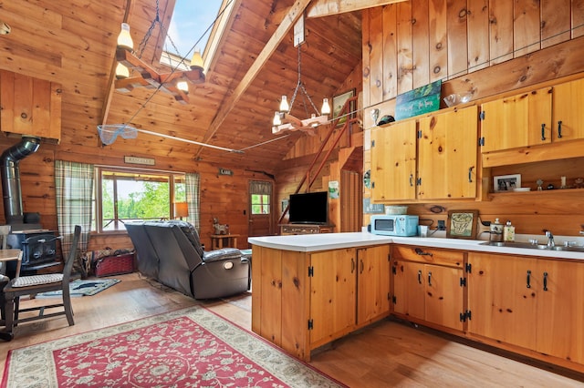 62 Hernborg Rd, Rangeley, ME 04970 - kitchen featuring open floor plan, light wood-style flooring, a wood stove, a skylight, and wooden ceiling