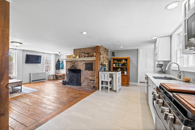 30 Joy Valley Rd, Buxton, ME 04093 - kitchen featuring a sink, white cabinets, light countertops, a brick fireplace, and recessed lighting