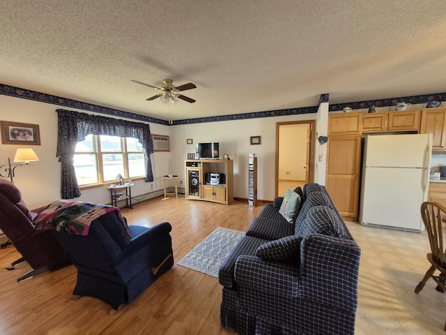 living area with a wall mounted air conditioner, a ceiling fan, light floors, and a textured ceiling