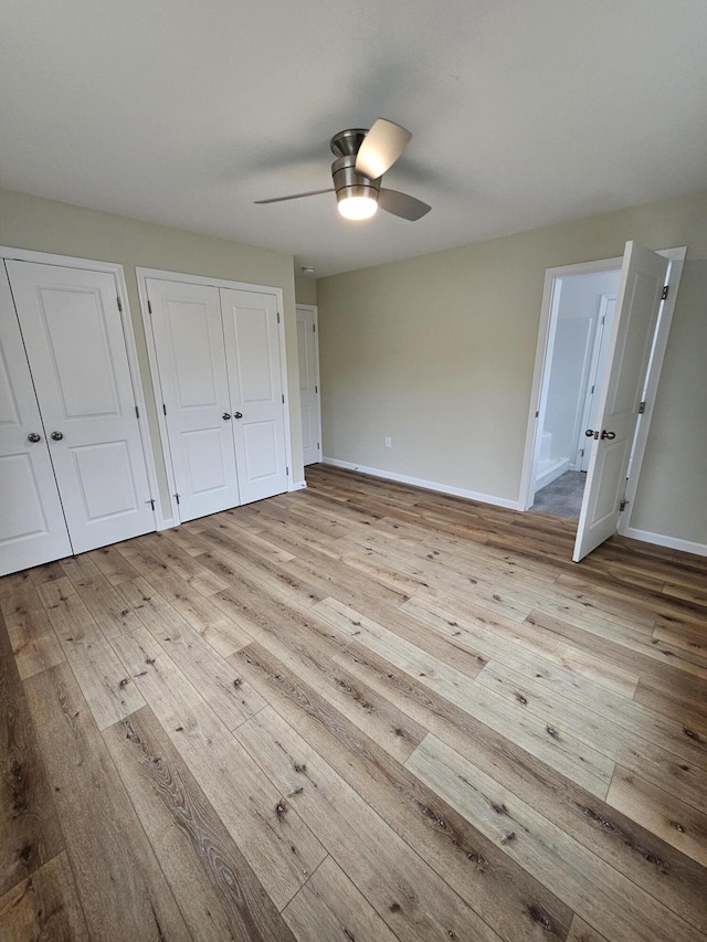310 Emery Mills Rd, Shapleigh, ME 04076 - unfurnished bedroom featuring hardwood / wood-style floors, two closets, and a ceiling fan