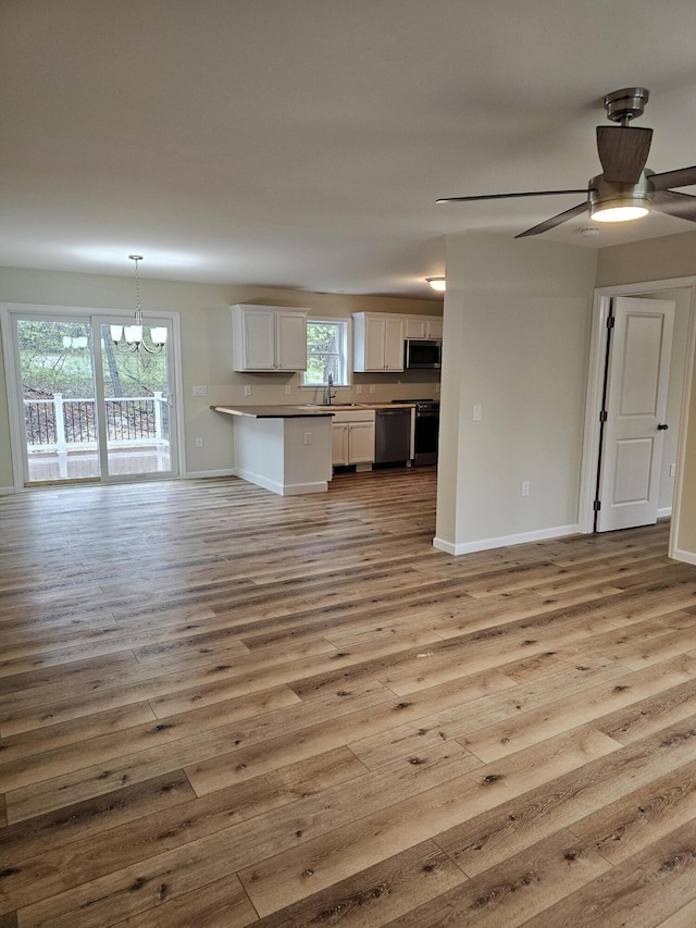 310 Emery Mills Rd, Shapleigh, ME 04076 - kitchen featuring open floor plan, range, stainless steel microwave, and light wood finished floors
