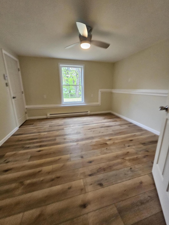310 Emery Mills Rd, Shapleigh, ME 04076 - spare room featuring a baseboard heating unit, wood finished floors, and ceiling fan