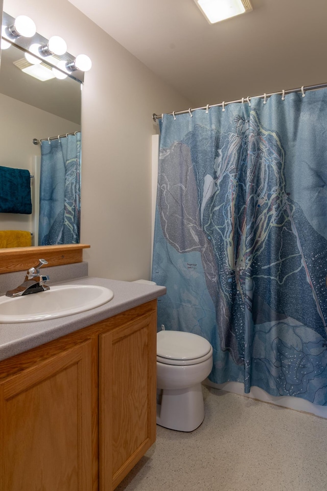 bathroom featuring vanity, a shower with shower curtain, and toilet