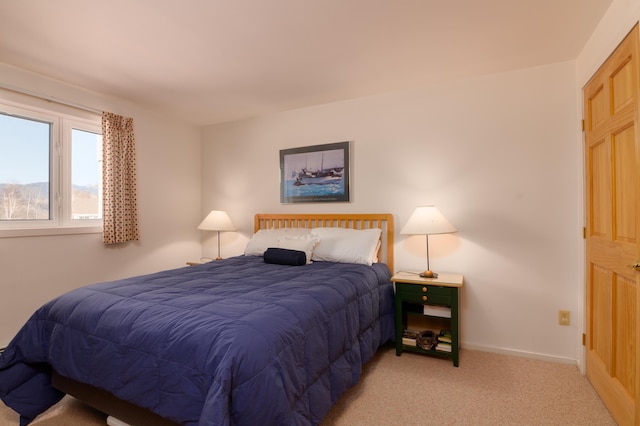 bedroom featuring baseboards and light carpet