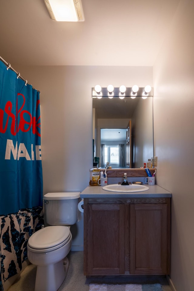 bathroom with toilet, vanity, and a shower with shower curtain