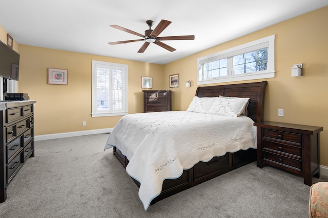 carpeted bedroom featuring multiple windows, baseboards, and ceiling fan