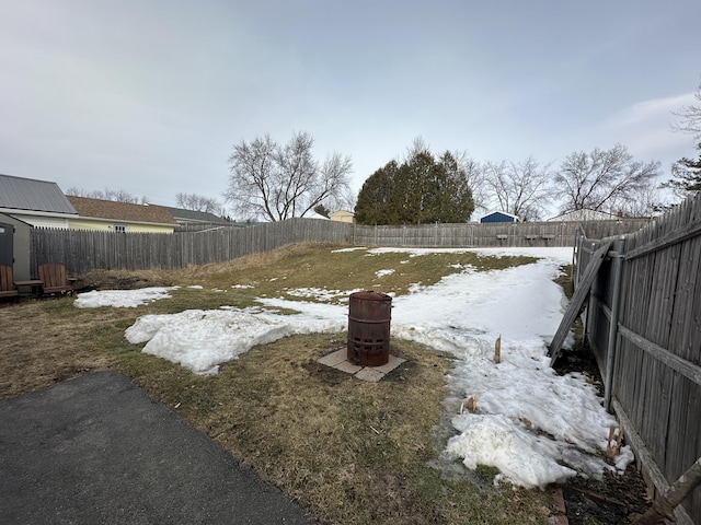 snowy yard with a fenced backyard