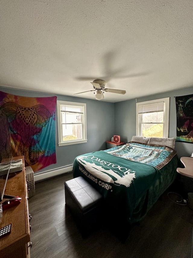 bedroom featuring baseboard heating, a textured ceiling, a ceiling fan, and wood finished floors