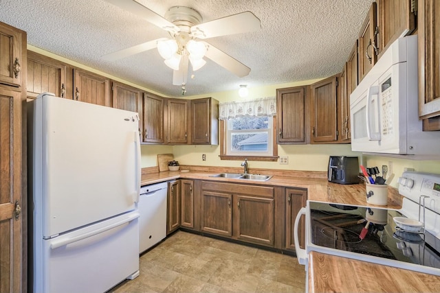 kitchen featuring white appliances, a ceiling fan, a sink, light countertops, and a textured ceiling