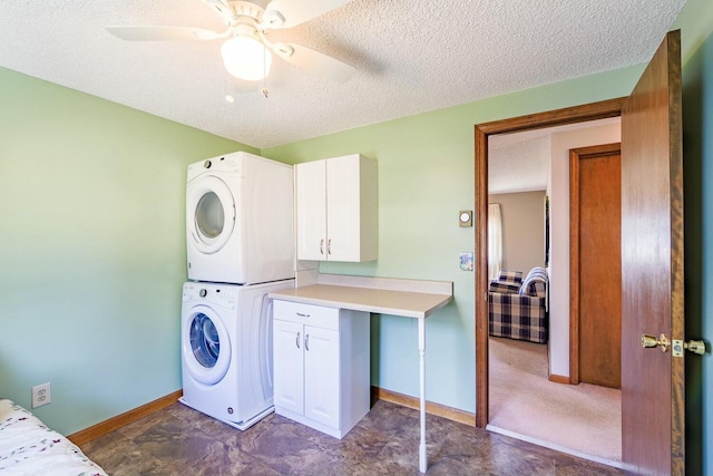 clothes washing area with stacked washer / dryer, cabinet space, a textured ceiling, and ceiling fan