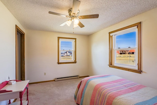 bedroom with baseboard heating, multiple windows, a textured ceiling, and carpet flooring