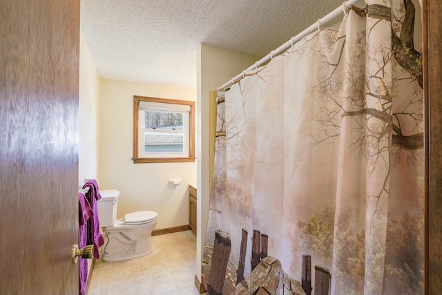 full bath with a shower with shower curtain, baseboards, a textured ceiling, tile patterned floors, and toilet