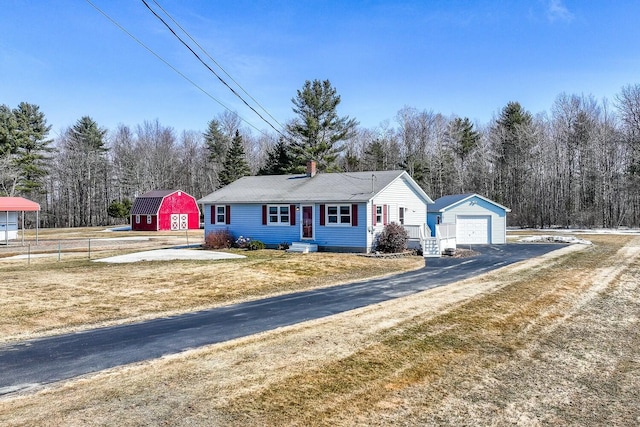 ranch-style home with an outbuilding, fence, driveway, and a detached garage