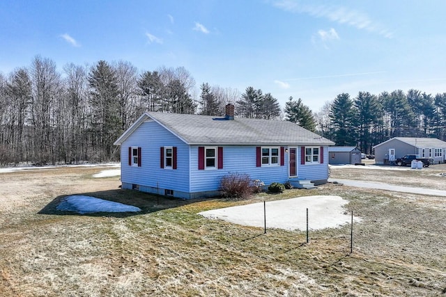 view of front of house with entry steps, a chimney, and a shingled roof