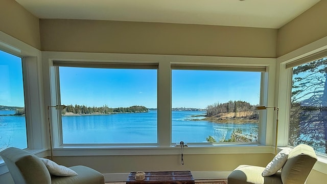 sunroom / solarium with baseboards and a water view