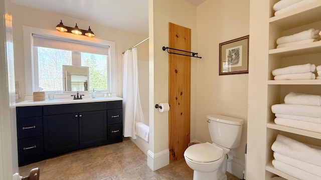 bathroom with baseboards, vanity, and toilet