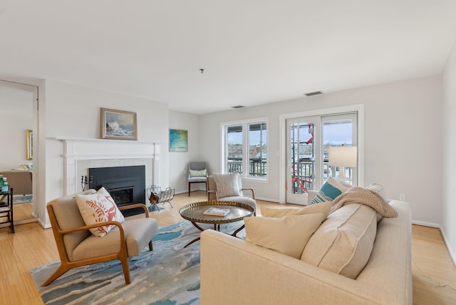 105 Chandlers Wharf Unit 105, Portland, ME 04101 - living area featuring a tiled fireplace, light wood-style floors, and baseboards