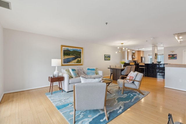 105 Chandlers Wharf Unit 105, Portland, ME 04101 - living area featuring light wood-style floors, baseboards, and a chandelier