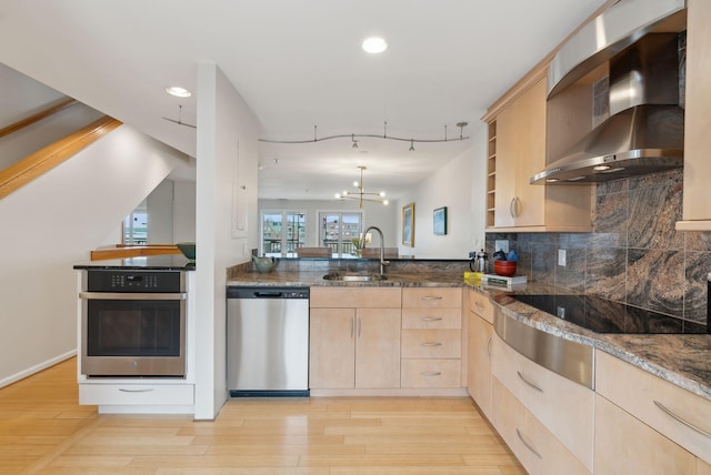 105 Chandlers Wharf Unit 105, Portland, ME 04101 - kitchen with appliances with stainless steel finishes, light brown cabinets, wall chimney range hood, a sink, and dark stone counters