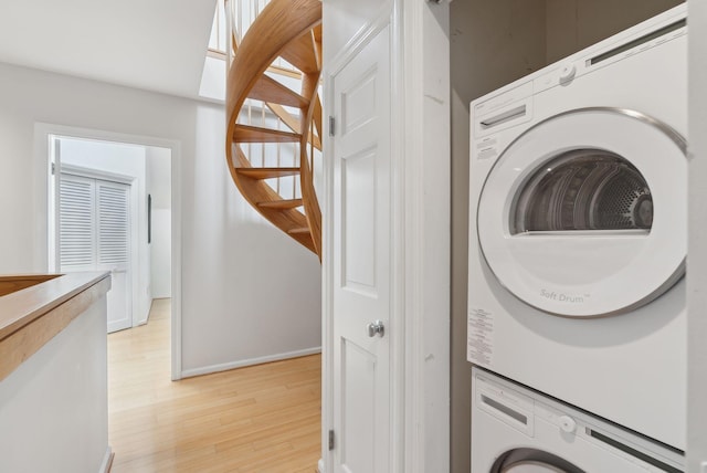 105 Chandlers Wharf Unit 105, Portland, ME 04101 - laundry room featuring stacked washer / dryer, light wood-style flooring, and baseboards