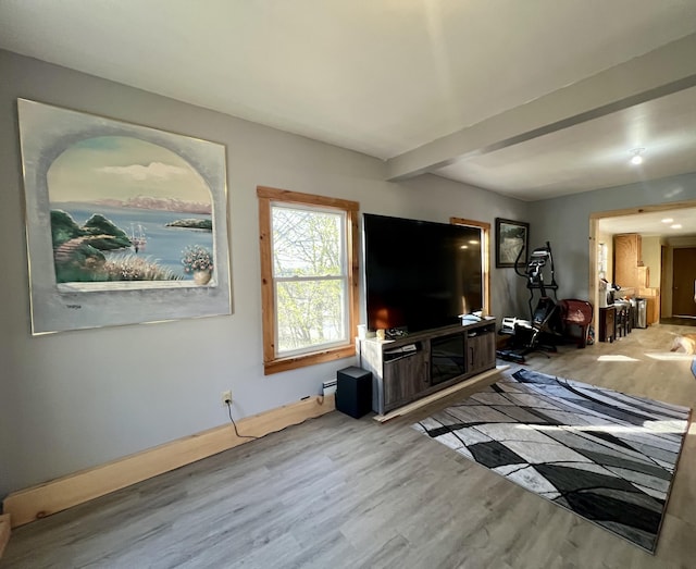 living area featuring baseboards, beam ceiling, and wood finished floors