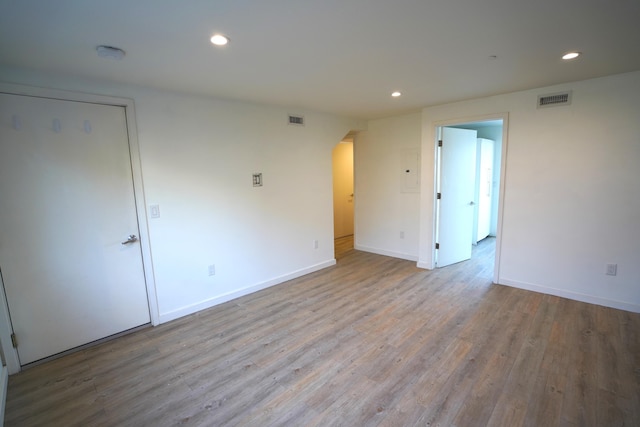 unfurnished room with arched walkways, visible vents, recessed lighting, and wood finished floors