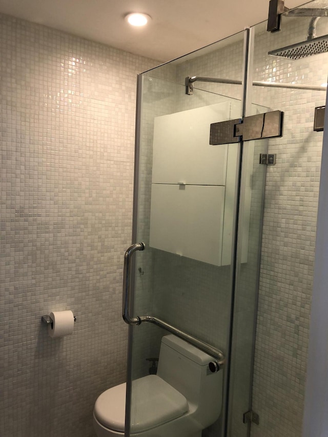 bathroom with a shower stall and toilet