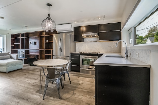 12 Romasco Ln, Portland, ME 04101 - kitchen with stainless steel appliances, a wall mounted AC, a sink, light countertops, and tasteful backsplash