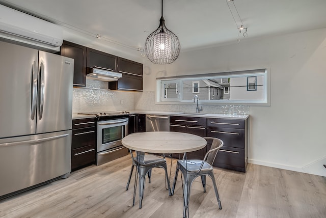 12 Romasco Ln, Portland, ME 04101 - kitchen with appliances with stainless steel finishes, a sink, light countertops, a wall mounted AC, and decorative backsplash