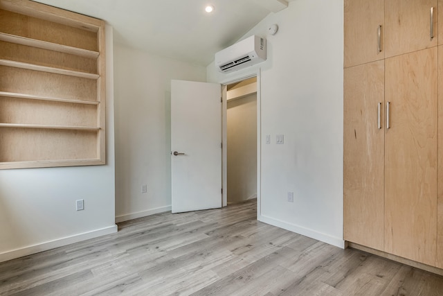 12 Romasco Ln, Portland, ME 04101 - unfurnished bedroom with a wall mounted AC, light wood-style flooring, baseboards, recessed lighting, and lofted ceiling