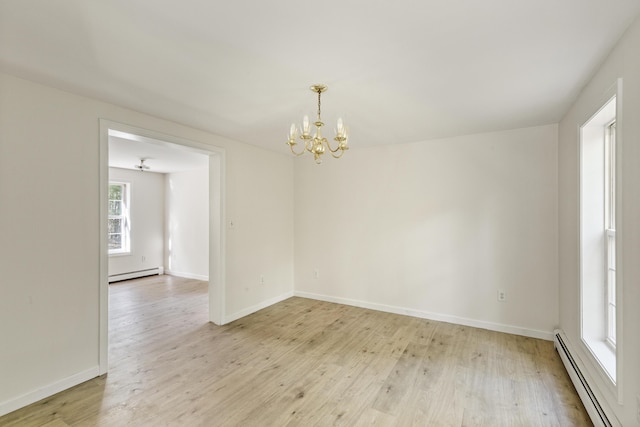 10 Trues Rd, Lincolnville, ME 04849 - spare room with a baseboard radiator, a chandelier, baseboard heating, light wood-style flooring, and baseboards