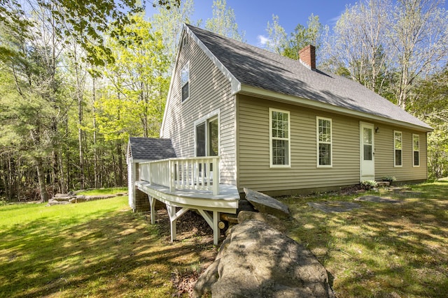 10 Trues Rd, Lincolnville, ME 04849 - view of side of home with a chimney, a deck, a lawn, and a shingled roof