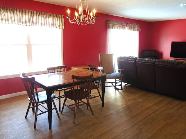 dining space with a notable chandelier, wood finished floors, and baseboards