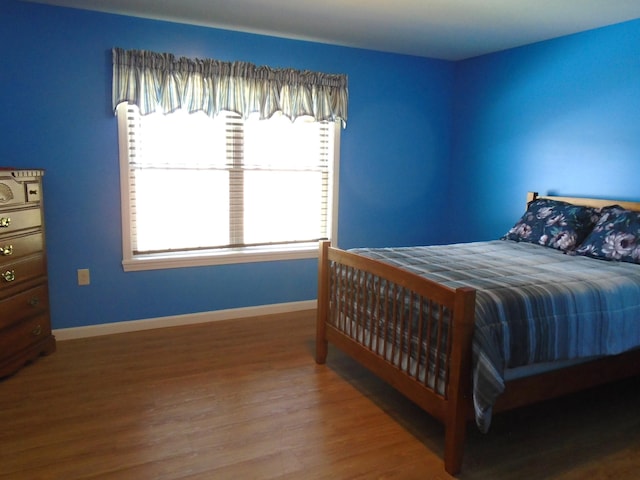 bedroom with baseboards and wood finished floors